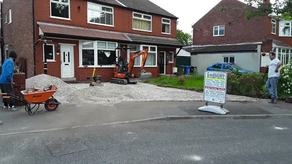Groundwork for a new driveway with digger and aggregate.