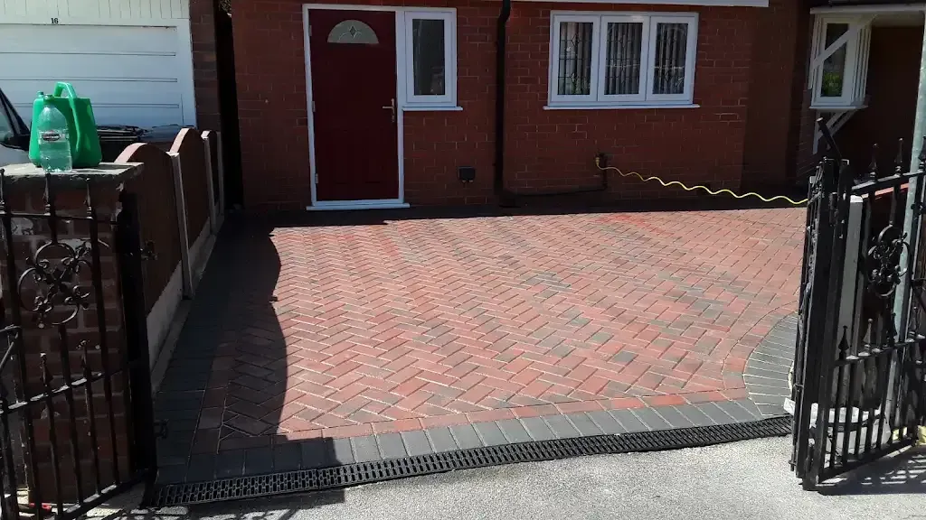 Newly installed block paved driveway with dark grey border and linear drainage channel