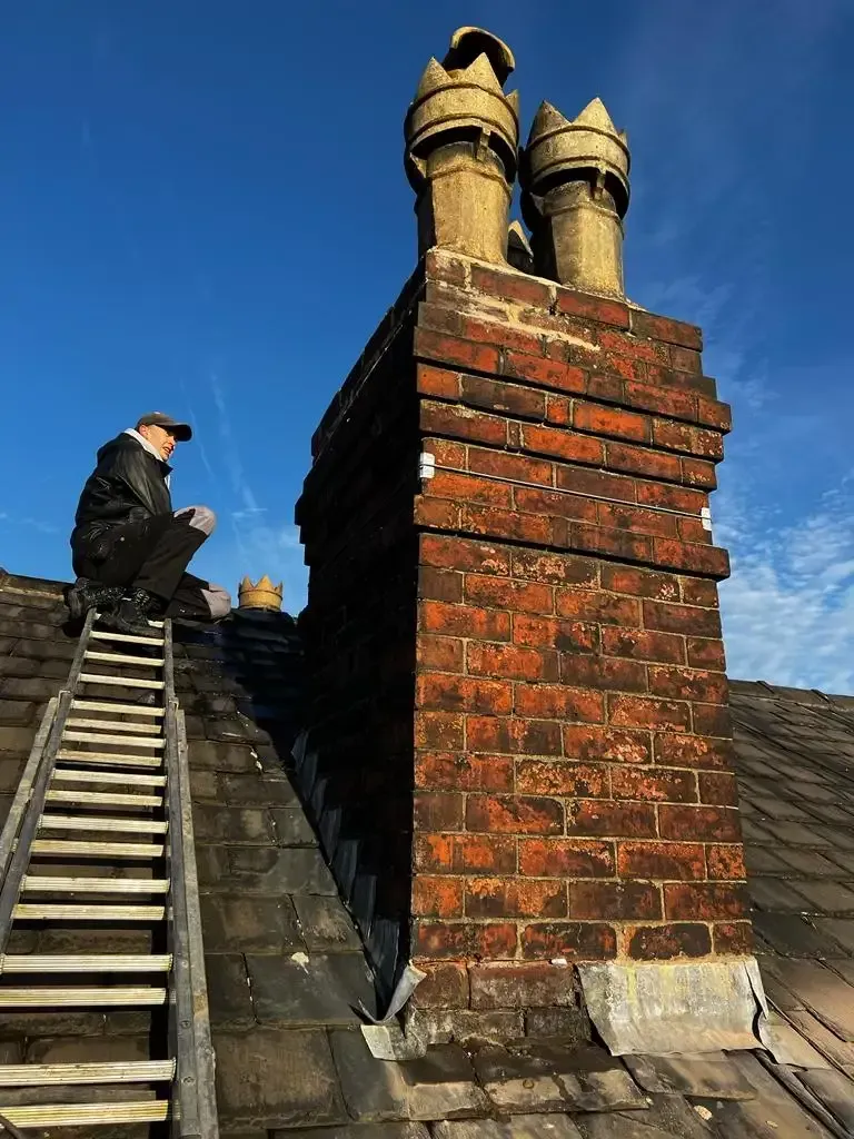 Roofer performing chimney repair on a residential property