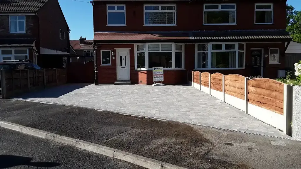 A picture of a completed block paved driveway and fence