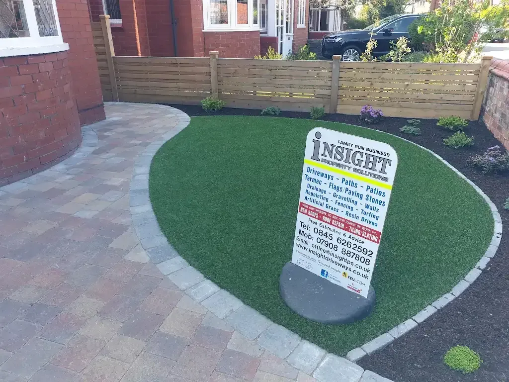 Newly installed block paved pathway and artificial grass lawn with garden borders