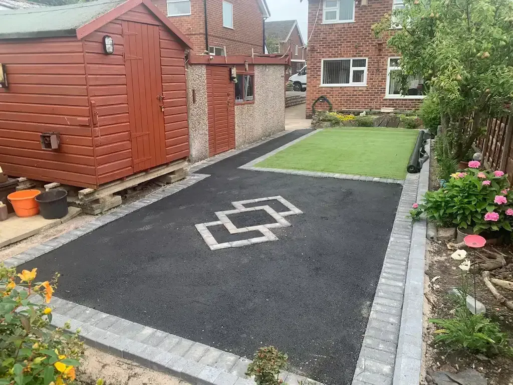 New tarmac driveway with block paving and artificial grass being installed in a garden by Insight PS.