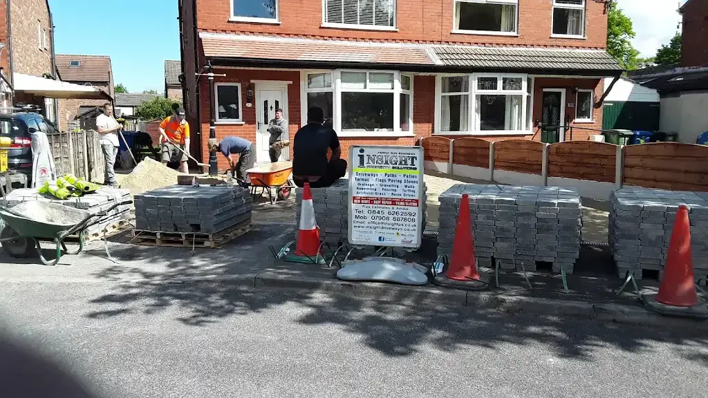 Workers laying block paving for a new driveway