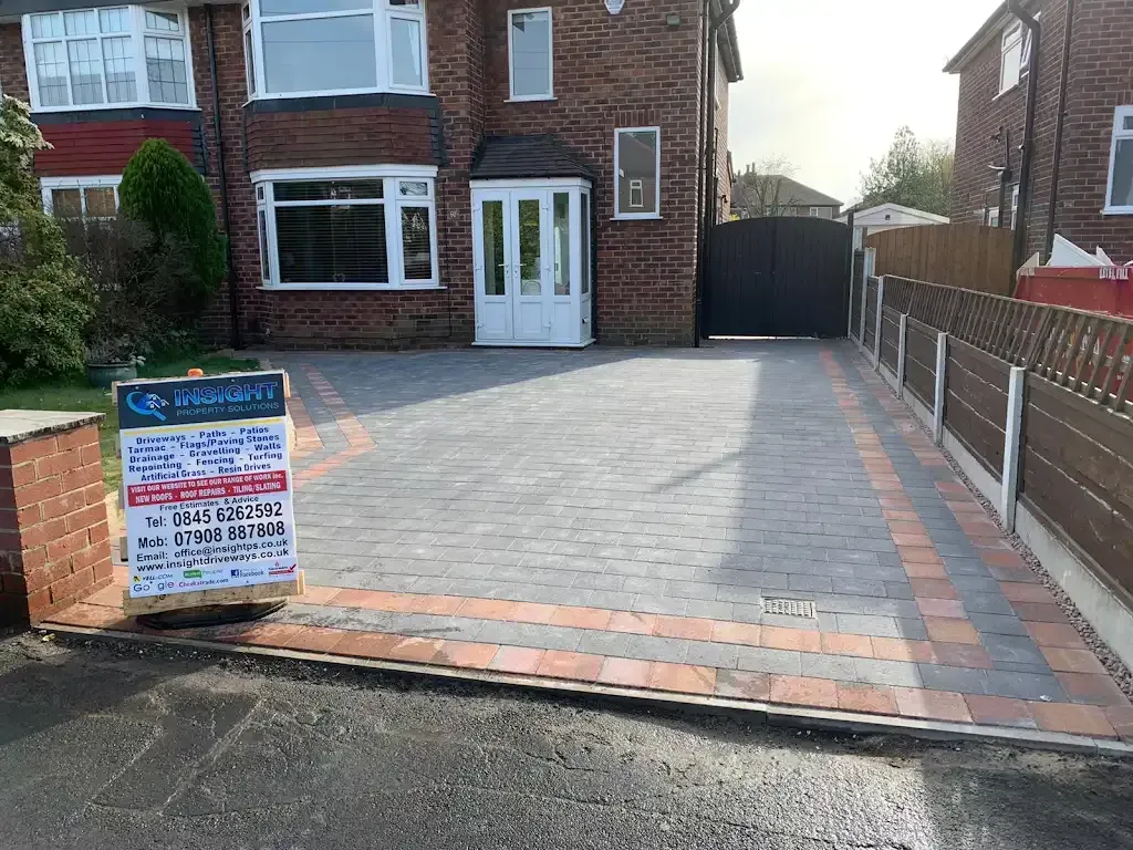 Newly installed block paving driveway with a company sign