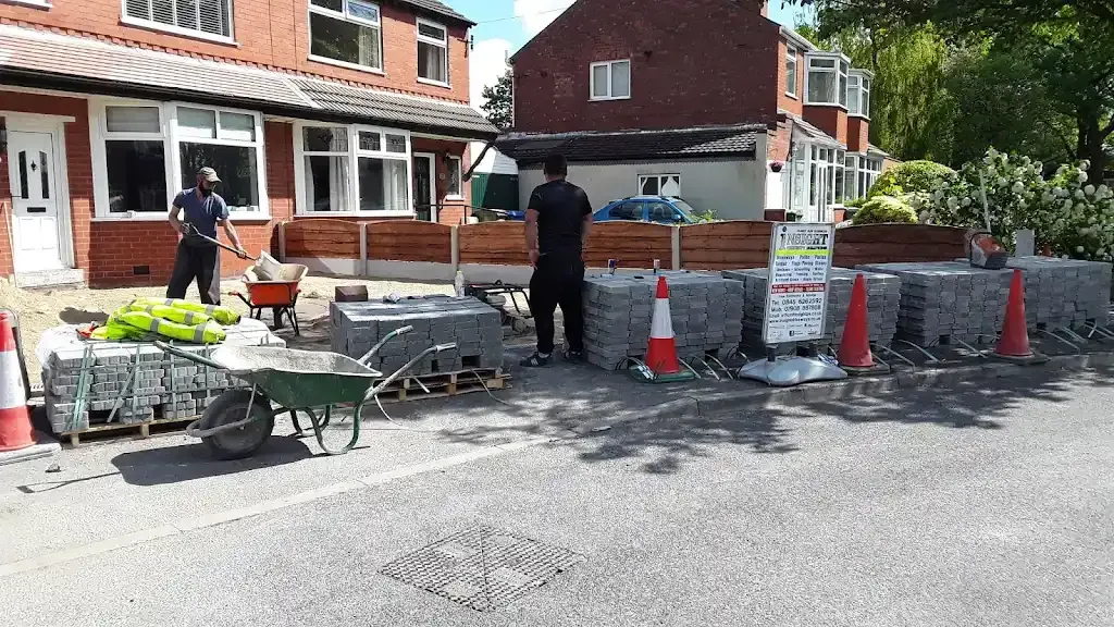 Workers laying block paving for a new driveway installation