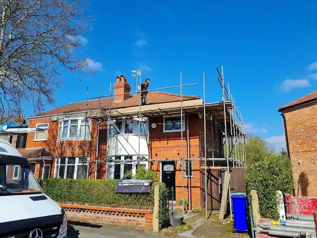 Roofing contractors from Insight PS working on a tiled roof of a house.