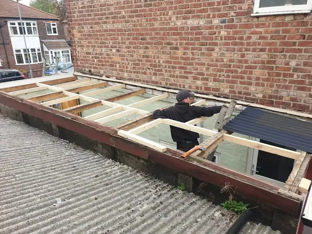 A roofer installing wooden joists for a flat roof