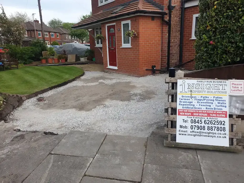 Ground preparation with laid aggregate for a new driveway or patio outside a house.