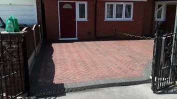 Newly installed block paved driveway with dark grey border and drainage channel.
